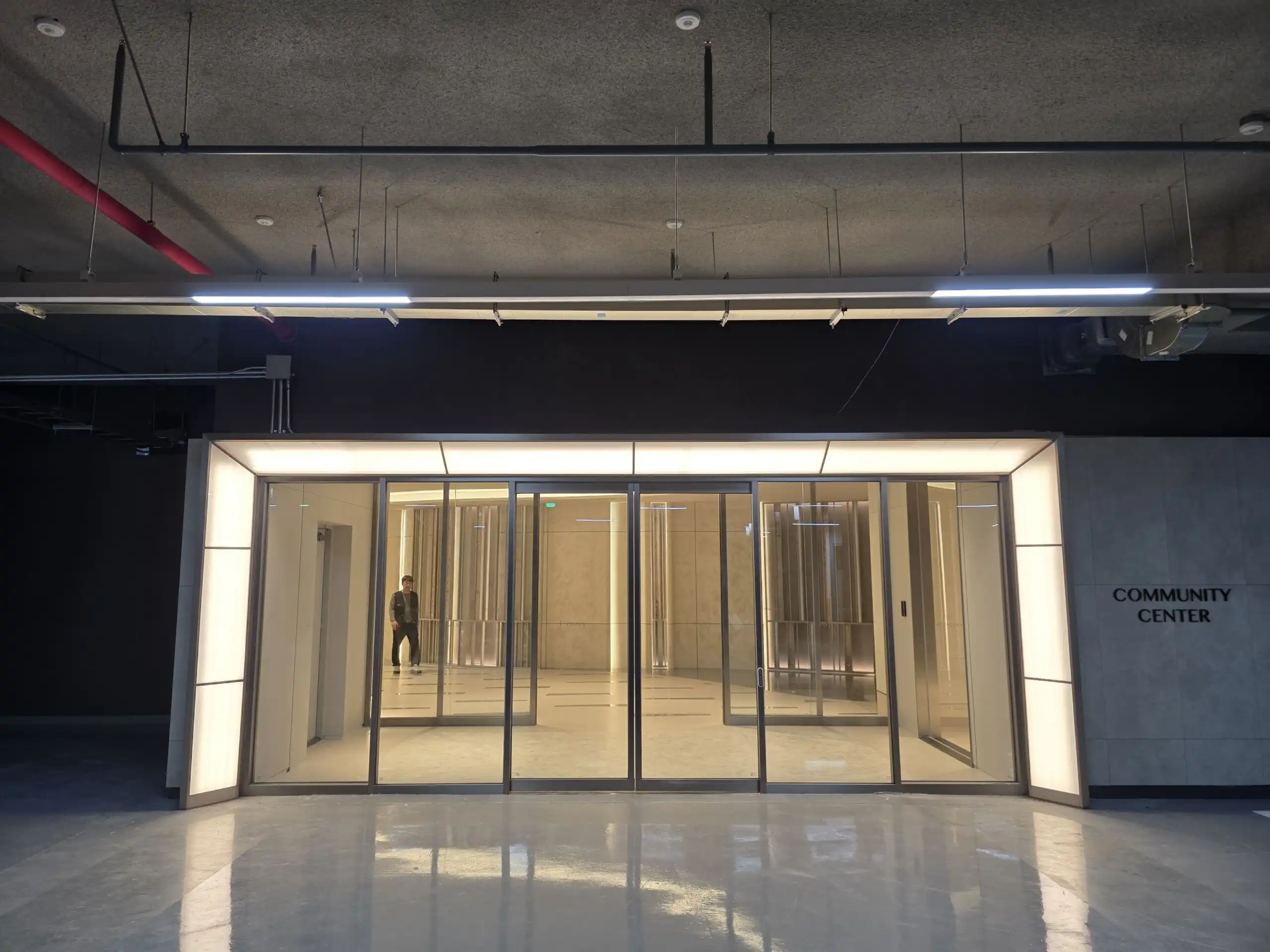 Contemporary community center entrance with glass doors at Pozes Hangang luxury apartments.