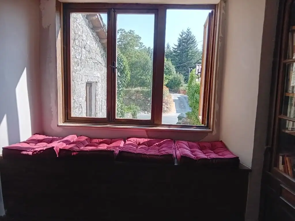 Beautiful stone house window in Chantada, Lugo, showcasing scenic outdoor views.