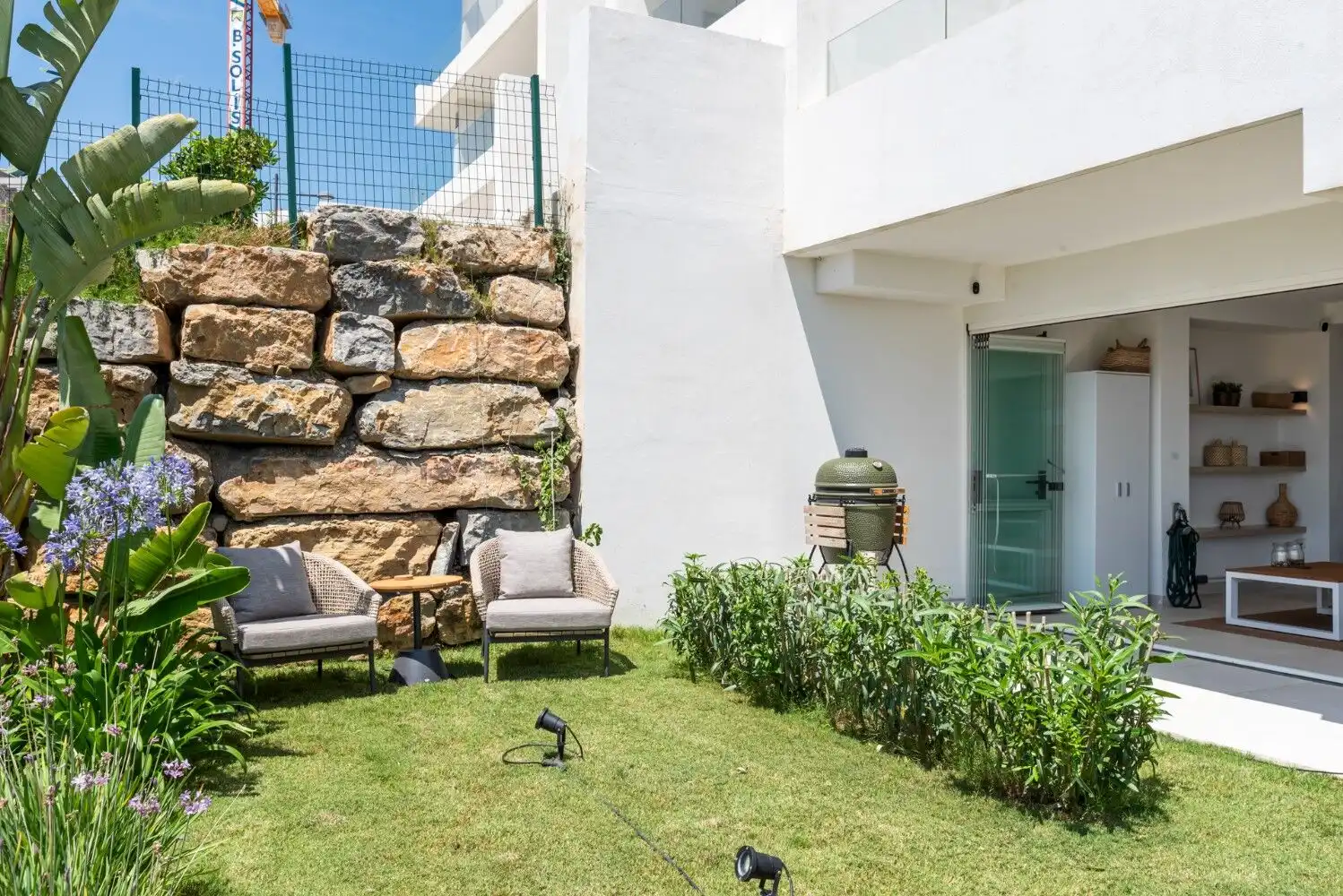 Outdoor garden with seating and lush greenery in a contemporary apartment.