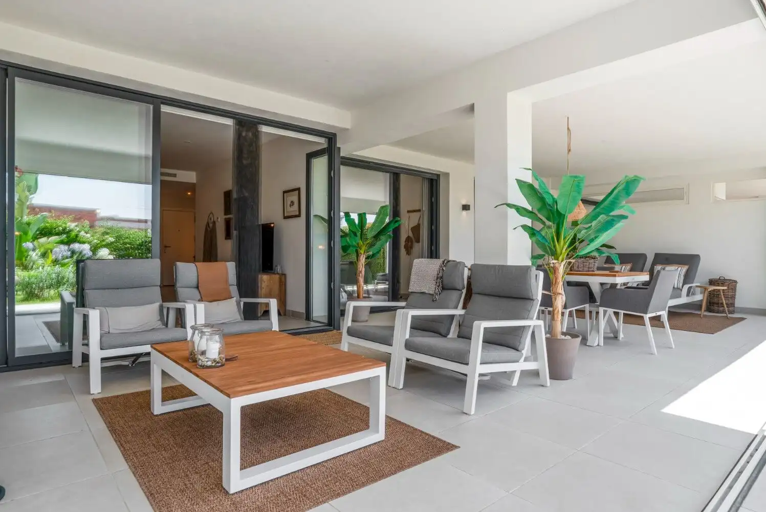 Spacious contemporary ground-floor apartment with outdoor seating and lush greenery views.