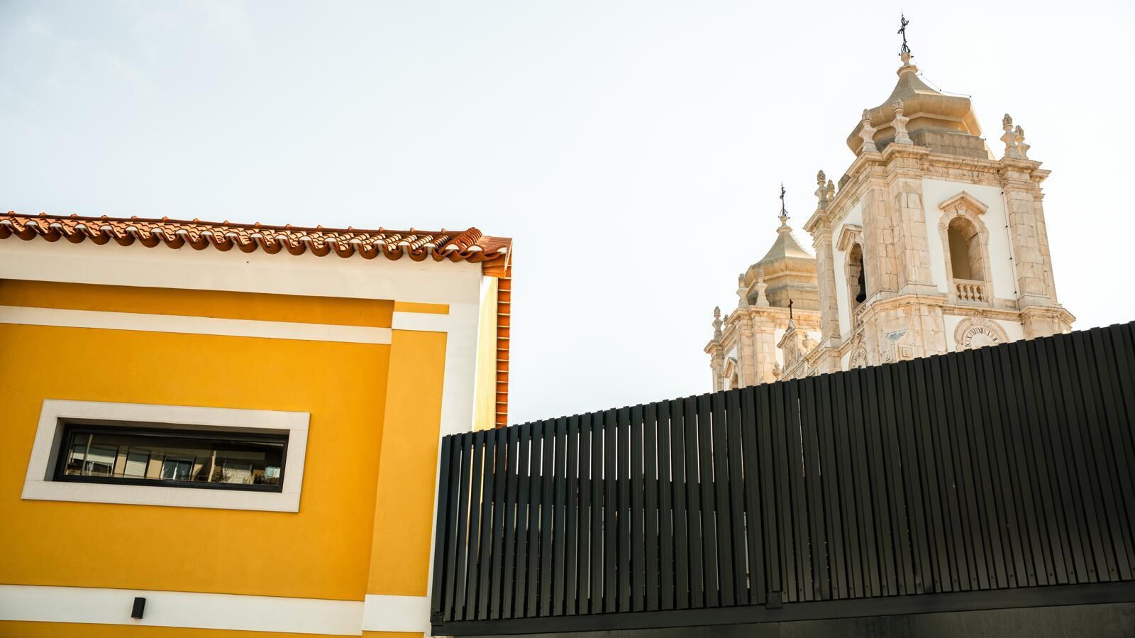 Charming boutique hotel exterior in Leiria, Portugal with historic architecture and vibrant yellow f.