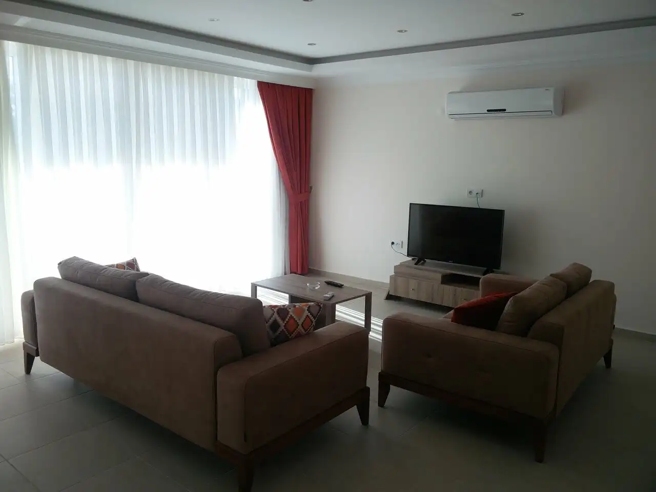 Modern living room with stylish furniture and large window in Orka Residence, Ovacık.