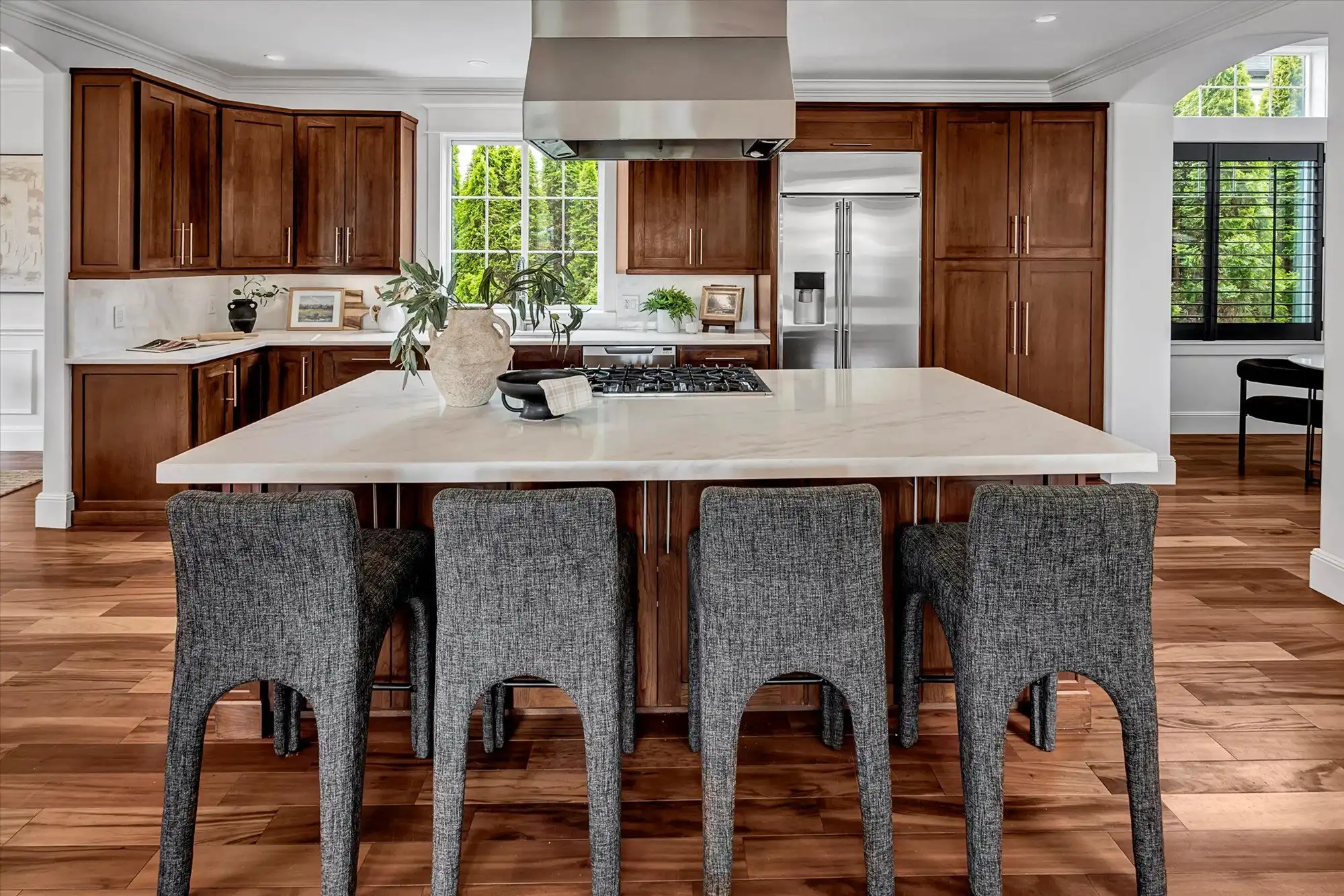 Spacious modern kitchen with island and wooden cabinets in a luxury lakefront home.