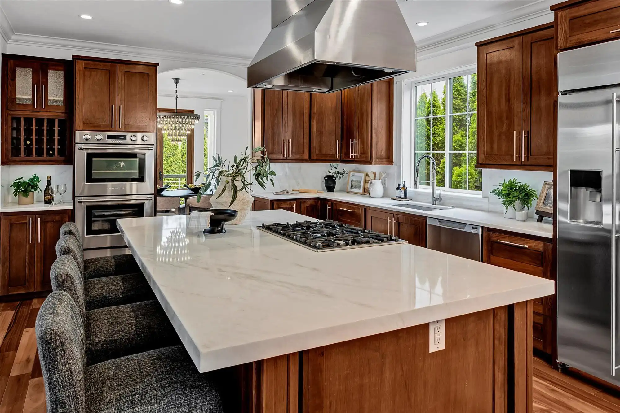 Elegant modern kitchen with custom wood cabinets and a large island in a stunning lakefront property.