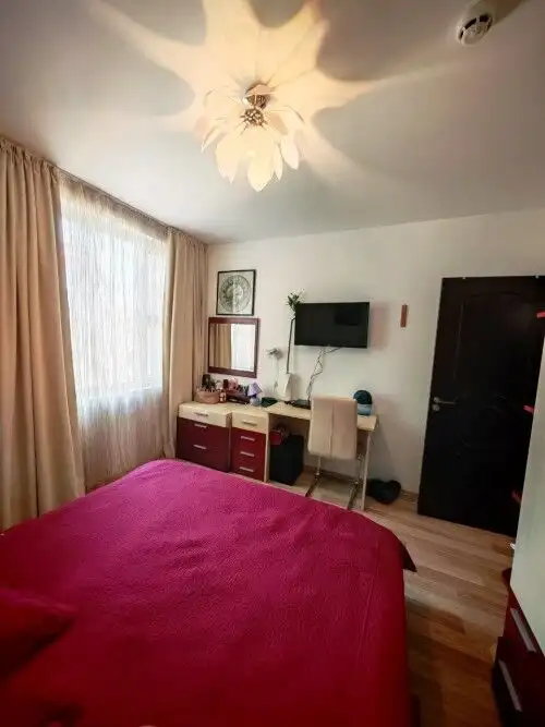 Interior of a 1-bedroom apartment with a pink bed, TV, and desk in Sveti Vlas, 300m from the sea.