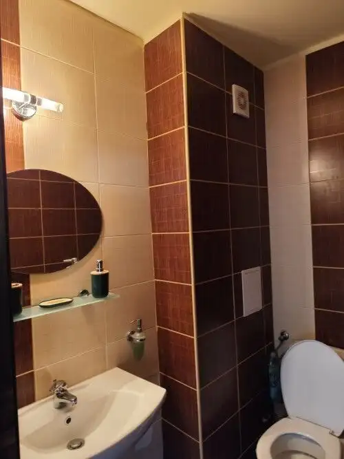 Bathroom with sink, mirror, and toilet in SunSet Ravda apartment.