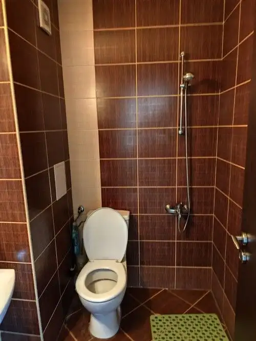 Bathroom with modern fixtures and brown tiled walls in a 1-bedroom sea view apartment in Ravda.