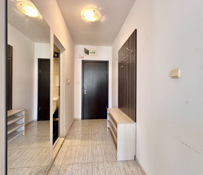 Bright hallway with large mirror and wooden storage units, leading to a modern apartment in Sunny Be.