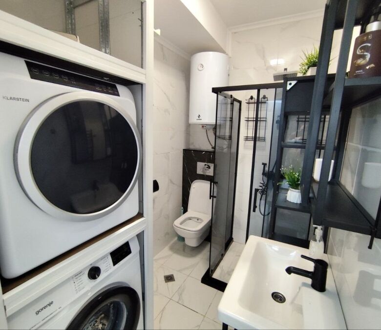 Modern bathroom with washing machine and shower in Sol E Mar, Sunny Beach. Compact space with essent.