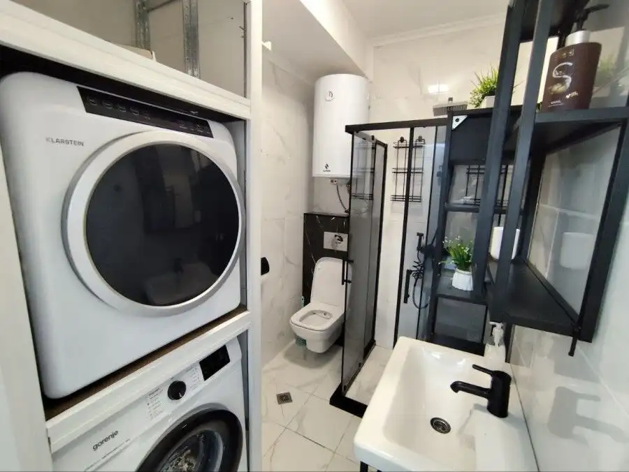 Modern bathroom with washing machine and shower in Sol E Mar, Sunny Beach. Compact space with essent.