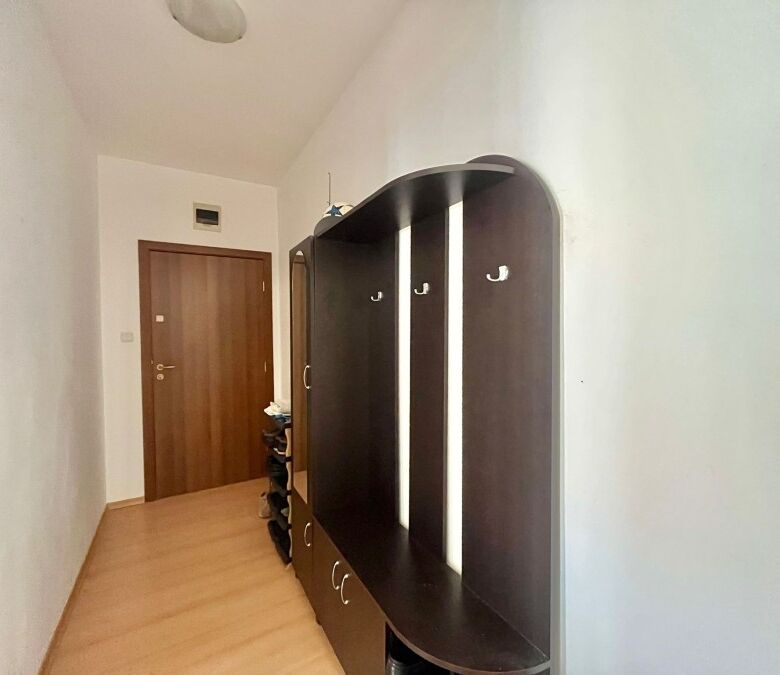 Modern fully furnished 2-bedroom apartment hallway with wardrobe and shoe storage, near the coast.