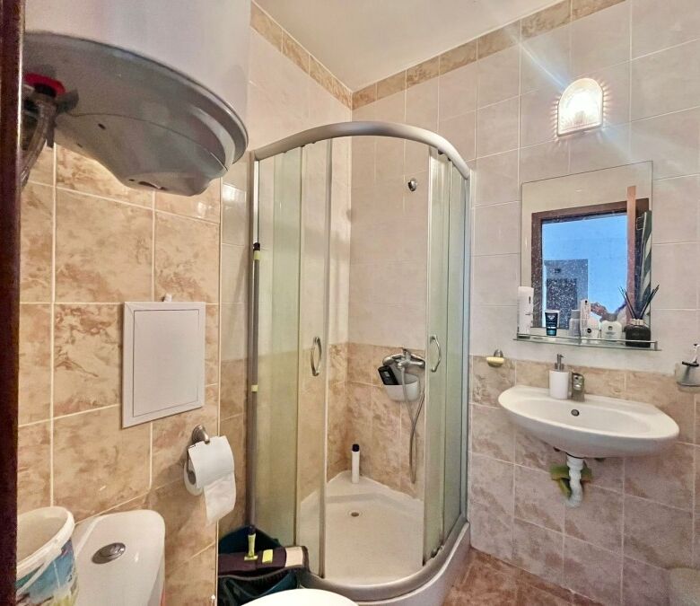 Modern bathroom with shower enclosure and essential fixtures.