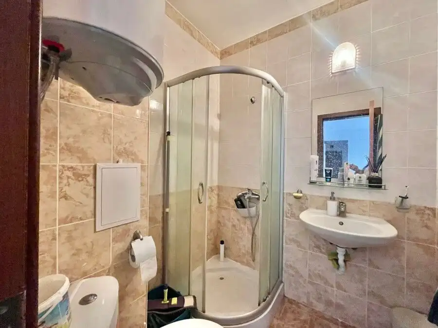Modern bathroom with shower enclosure and essential fixtures.
