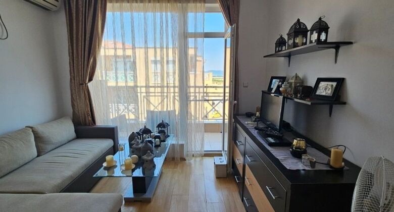 Bright living room with large windows and balcony access, showcasing stunning city and mountain vist.