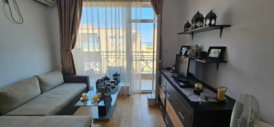 Bright living room with large windows and balcony access, showcasing stunning city and mountain vist.