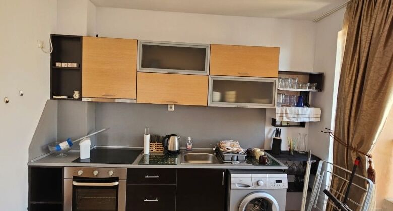Bright kitchen featuring appliances, cabinets, and a window with curtains.