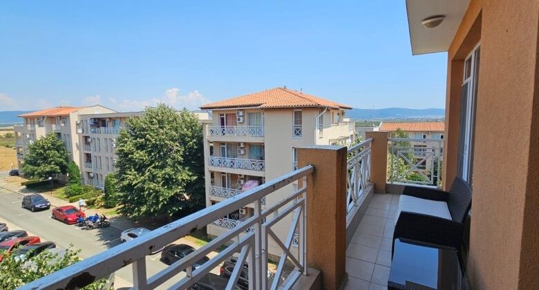 Balcony with panoramic views and outdoor seating in a modern apartment.
