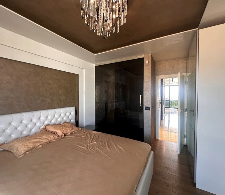 Penthouse bedroom with sea views, modern decor, and access to a spacious terrace in Sveti Vlas.