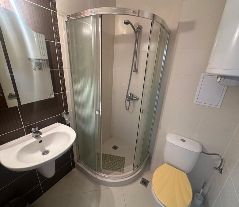 Modern bathroom with shower cabin and essential fixtures.