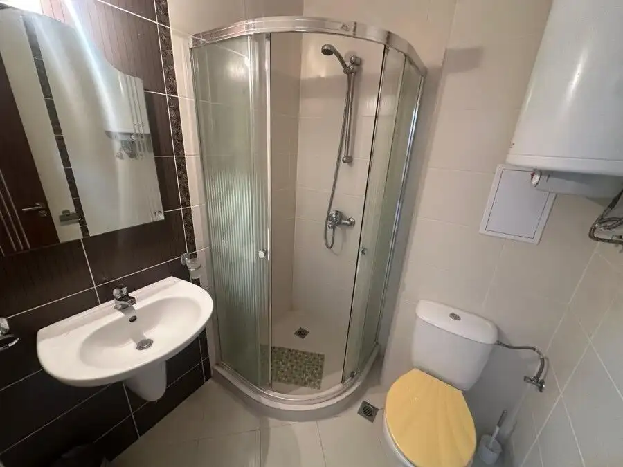 Modern bathroom with shower cabin and essential fixtures.