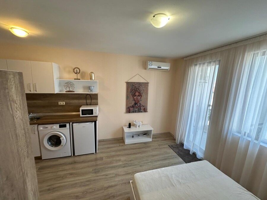 Cozy Studio Apartment in Apollon Ravda Interior view of a studio apartment with kitchen, washing machine, and living area in Apollon Ravda.