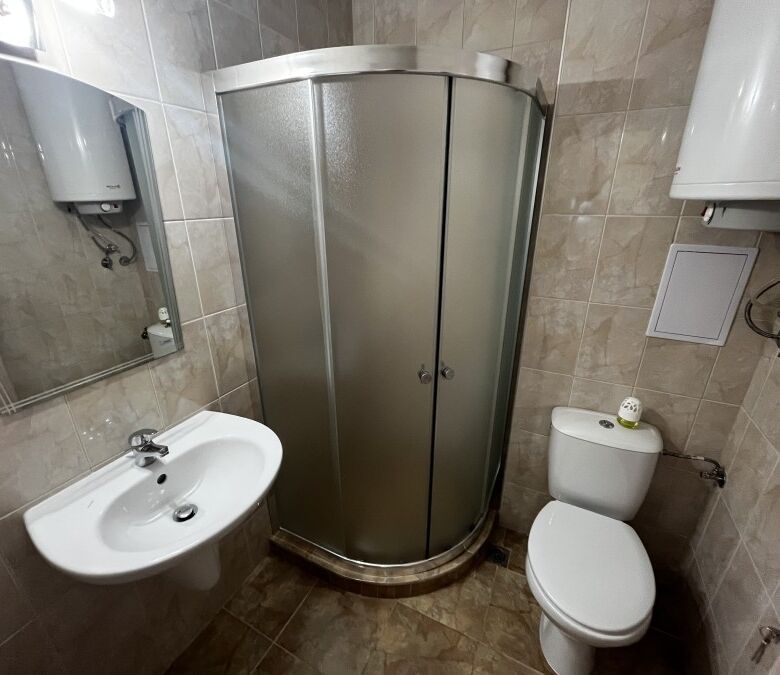 Compact bathroom with shower, toilet, and sink in Apollon apartments, Ravda.