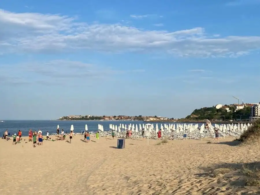 Beach view of Esperanto hotel with sunbeds and umbrellas on the seaside.