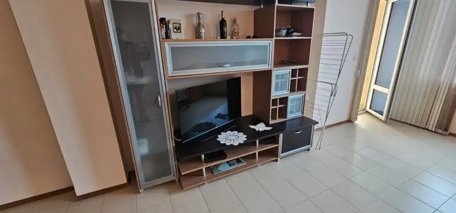 Bright living space with stylish furniture and balcony overlooking the sea.