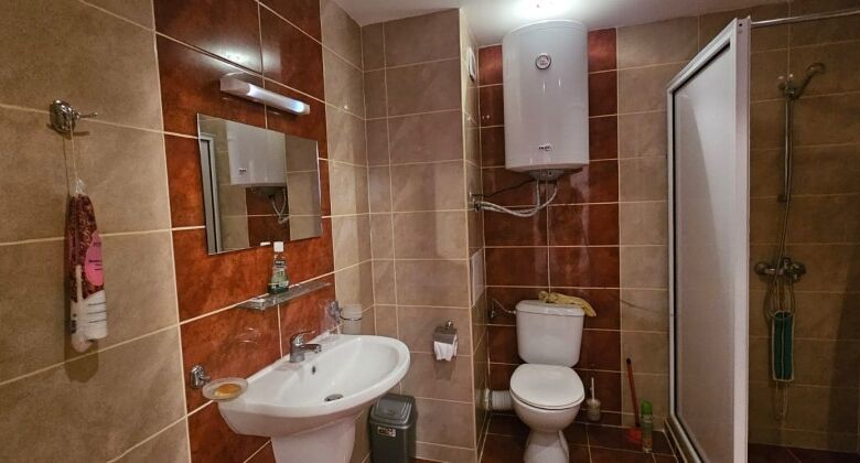 Bathroom with shower, toilet, and sink in a sea front hotel apartment.
