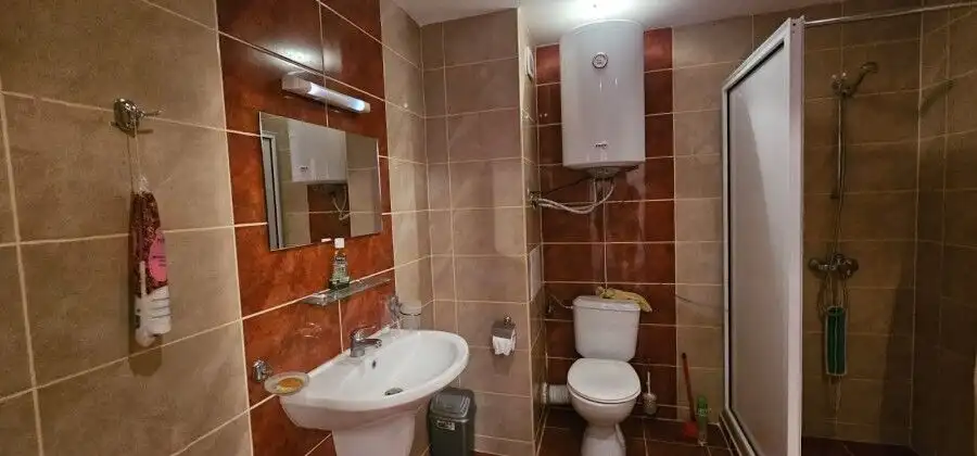 Bathroom with shower, toilet, and sink in a sea front hotel apartment.