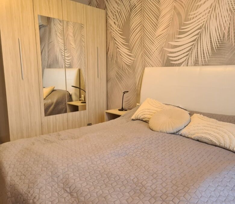 Furnished 2-bedroom apartment bedroom with bed, pillows, and wardrobe in Sunny Beach resort.