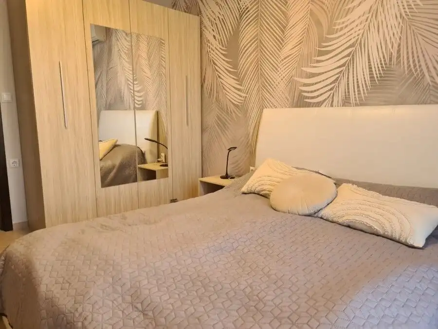 Furnished 2-bedroom apartment bedroom with bed, pillows, and wardrobe in Sunny Beach resort.