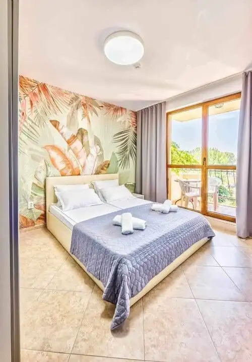 Modern furnished bedroom with balcony overlooking greenery at Cascadas Family Resort, Sunny Beach.