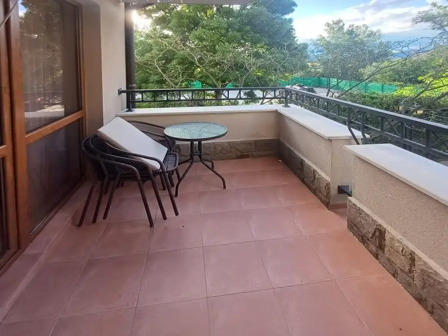 Balcony with pool view, outdoor seating, and lush greenery in Cascadas Family Resort, Sunny Beach.