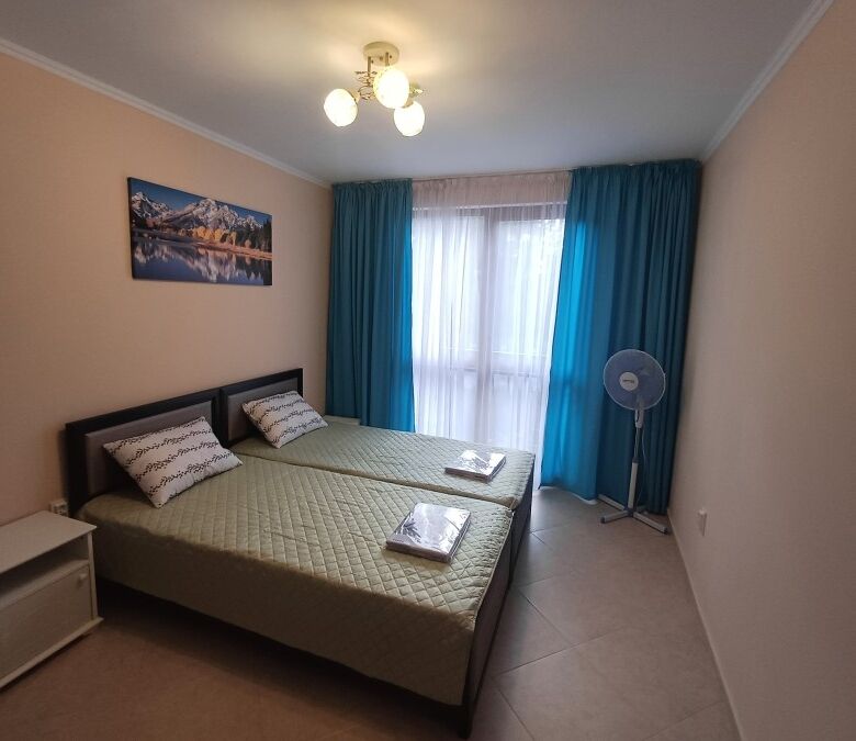 Bright bedroom with pool view, double beds, and balcony in Cascadas Family Resort.