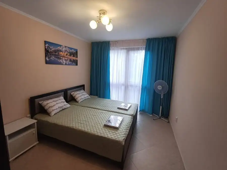 Bright bedroom with pool view, double beds, and balcony in Cascadas Family Resort.