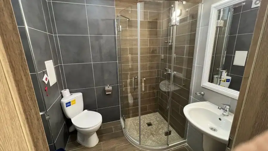 Modern bathroom with shower and new fixtures in a compact studio at Cascadas Family Resort.