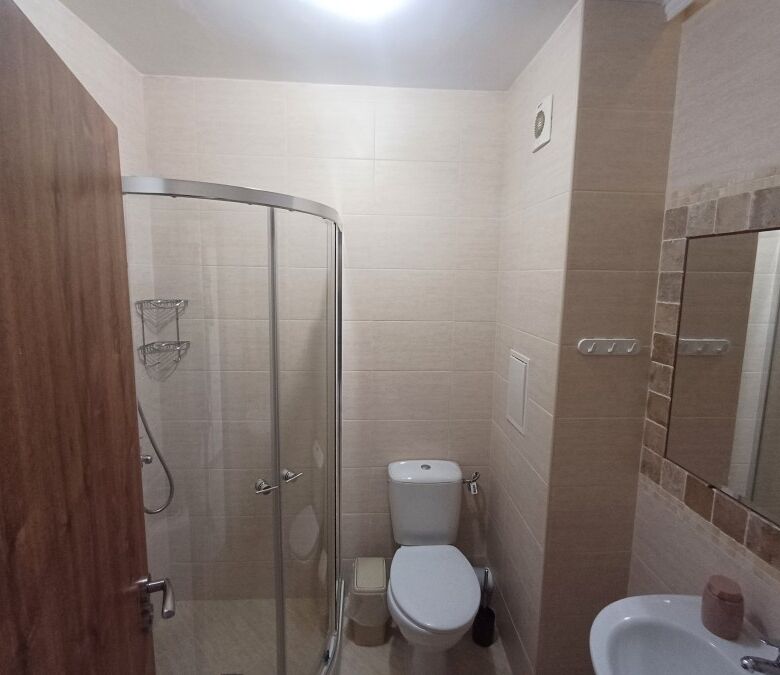 Compact studio bathroom with shower, toilet, and mirror in Cascadas Family Resort.