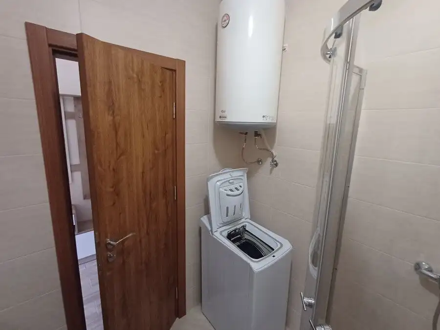 Compact bathroom with washing machine and water heater in Cascadas Family Resort.