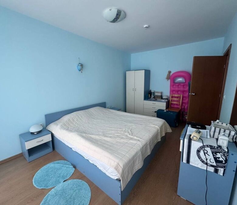 Bright bedroom with a large bed and modern furnishings in a seaside apartment.