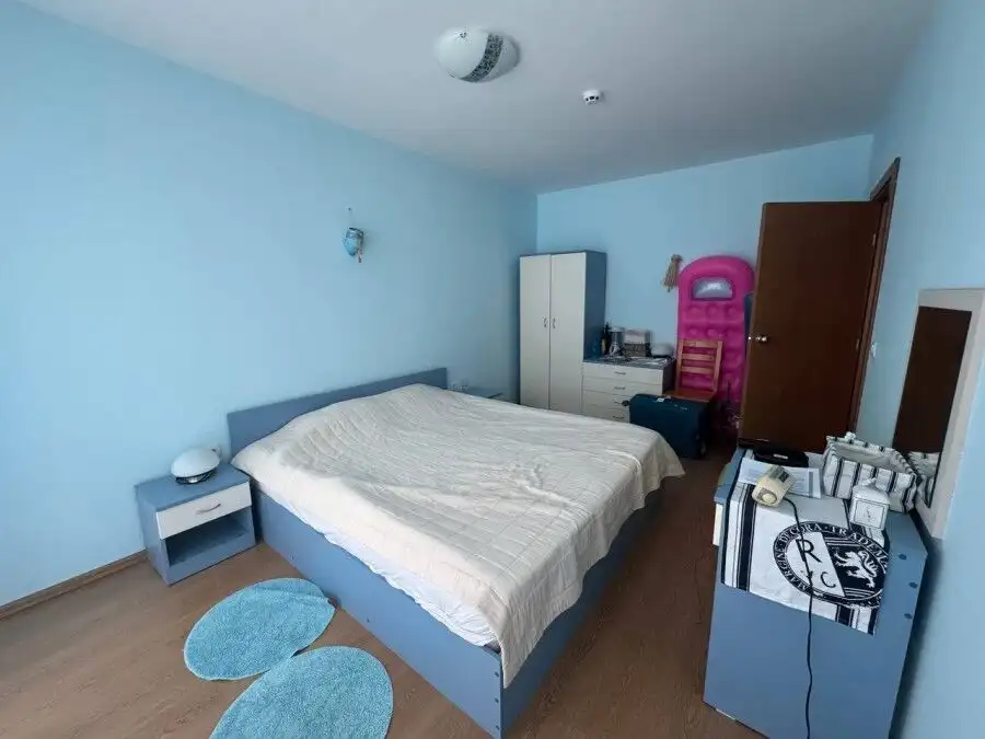Bright bedroom with a large bed and modern furnishings in a seaside apartment.