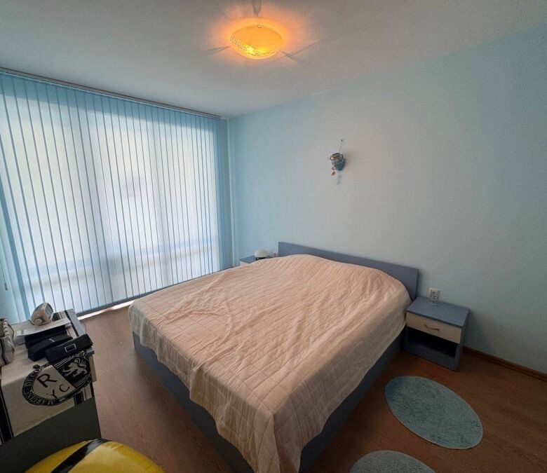 Cozy bedroom with large window overlooking the pool and sea in Sunny Beach.