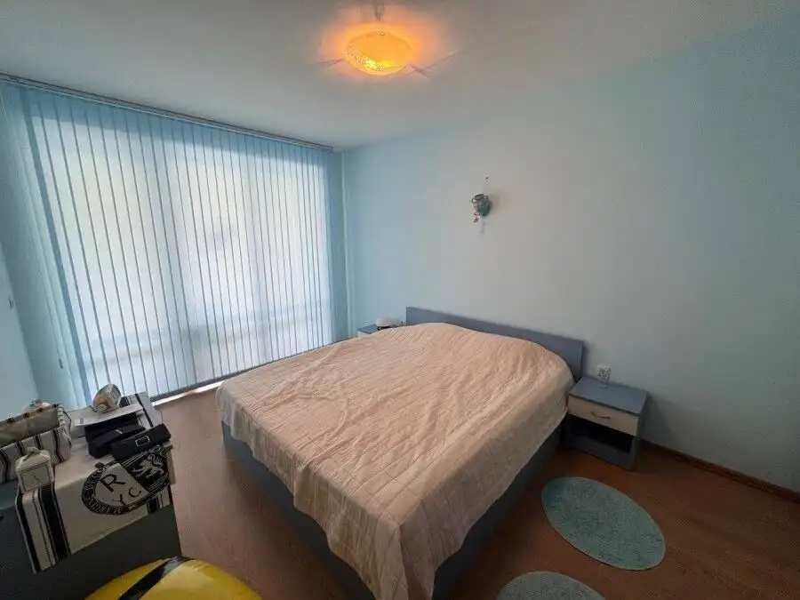 Cozy bedroom with large window overlooking the pool and sea in Sunny Beach.