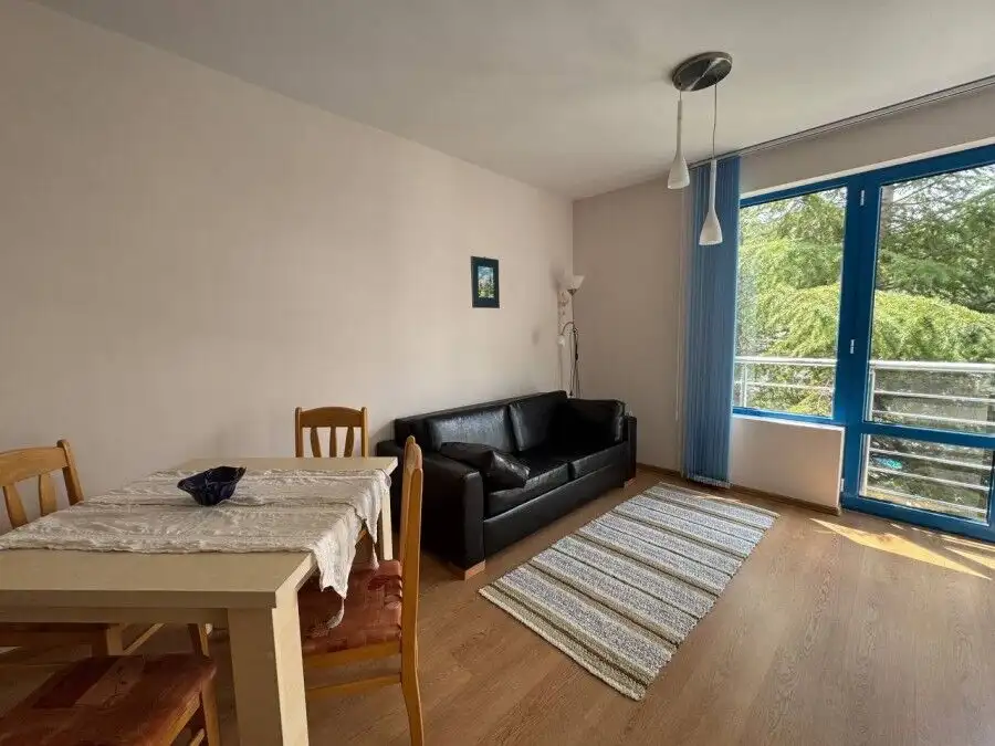 Interior of a 1-bedroom apartment with pool view, sunny beach, and balcony.