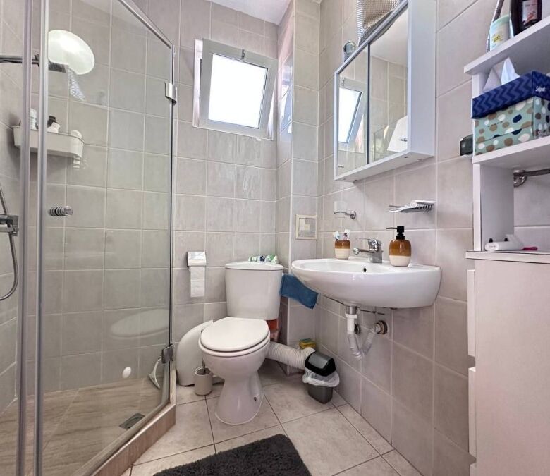 Bright bathroom with shower, toilet, and sink in Robinson Gardens, Sunny Beach.