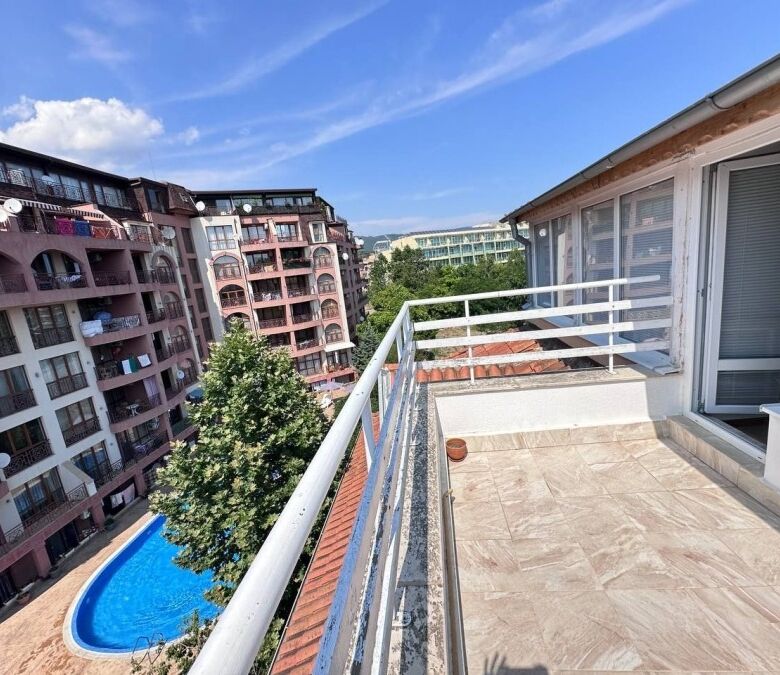 Balcony view of Robinson Gardens with pool and surrounding apartment buildings in Sunny Beach.