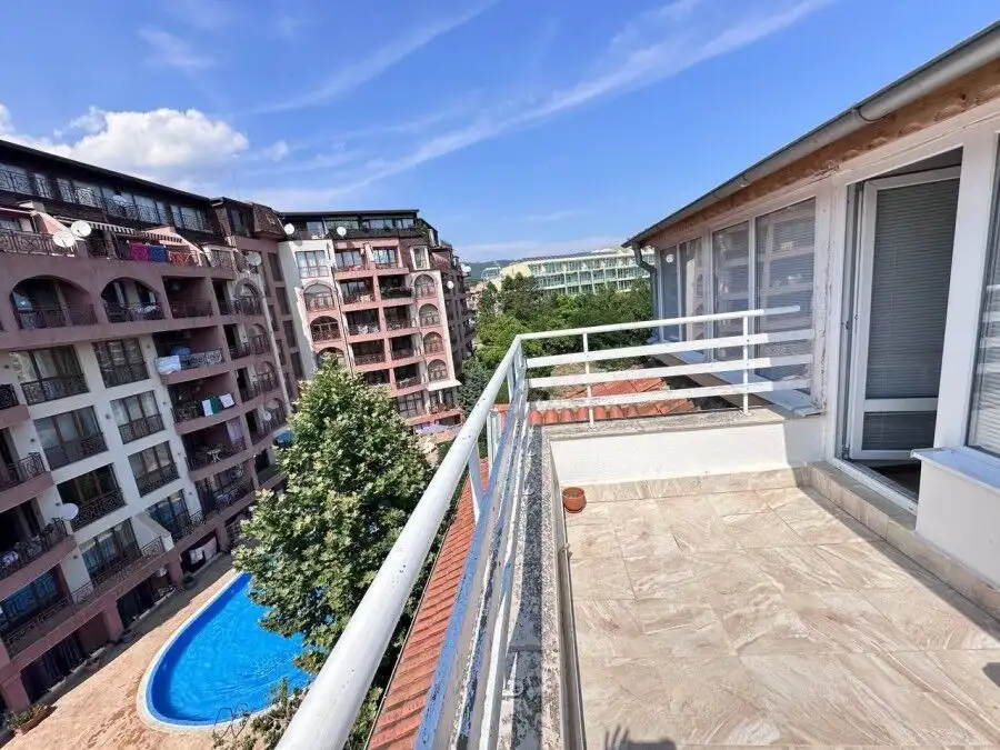Balcony view of Robinson Gardens with pool and surrounding apartment buildings in Sunny Beach.