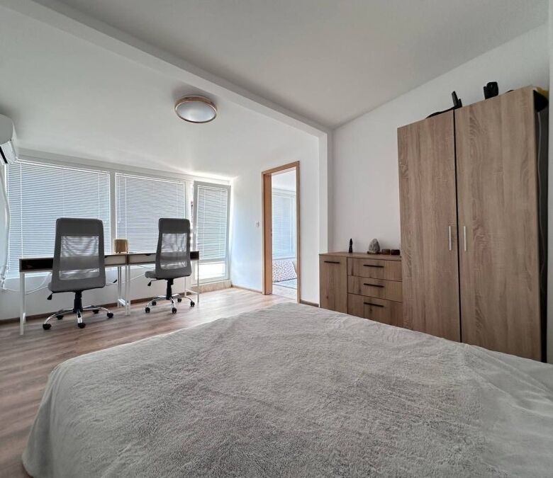Bright and modern bedroom with large windows and contemporary furnishings.