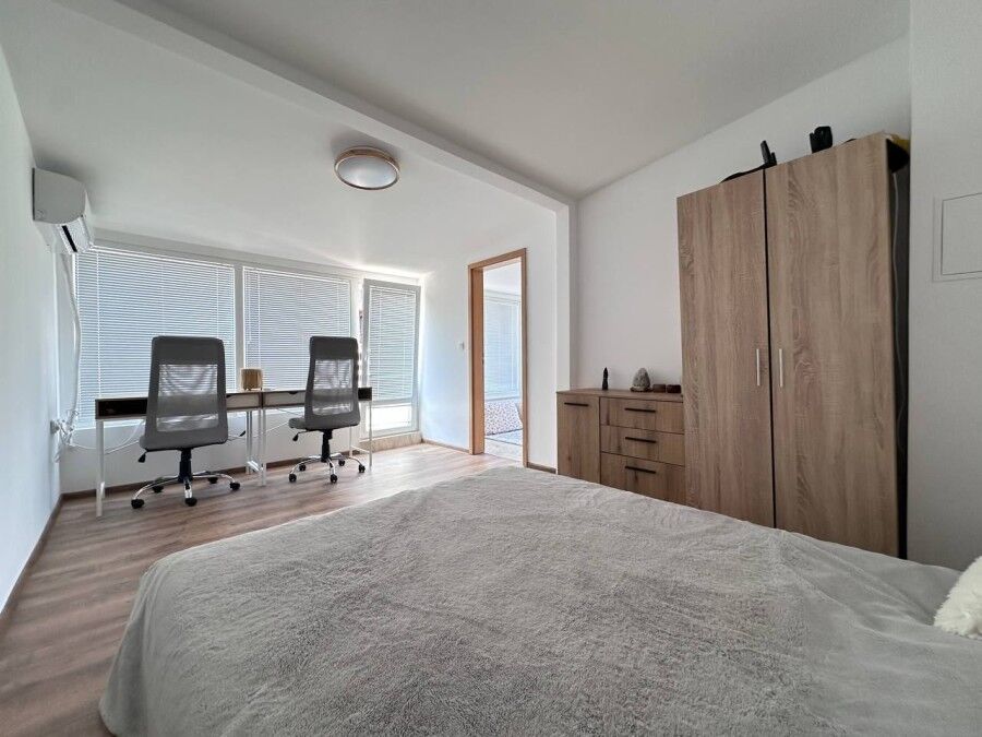 Bright and modern bedroom with large windows and contemporary furnishings.