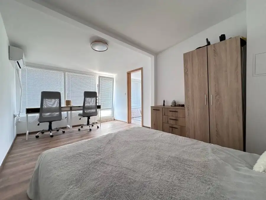Bright and modern bedroom with large windows and contemporary furnishings.